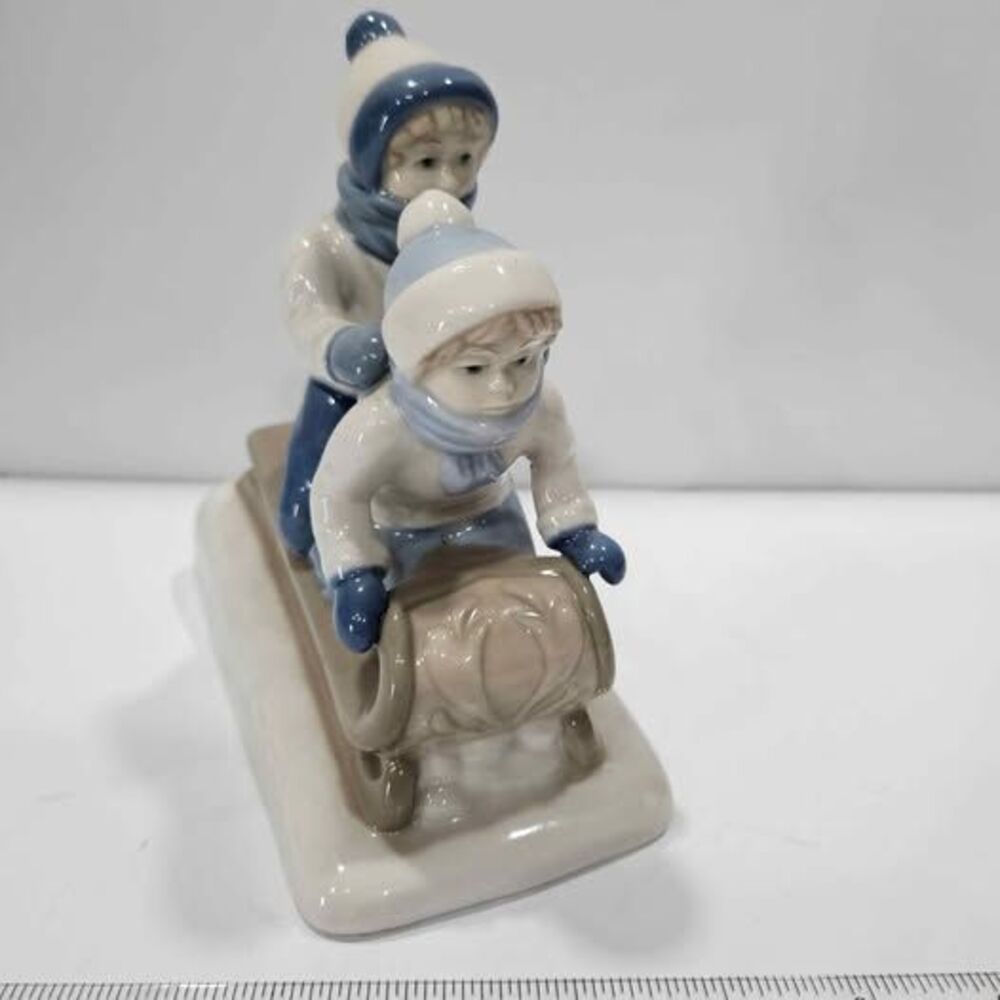 Porcelain figurine kids on sled winter decor